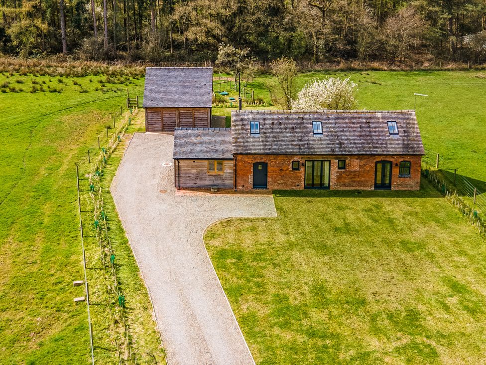 A house and garage with a gravel driveway at Johnsons Smallholding in Market Drayton