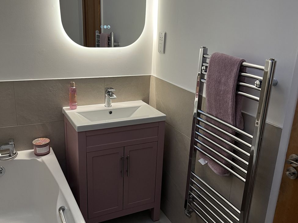A bathroom with a vanity sink and towel rail at Seascape in Kingsand