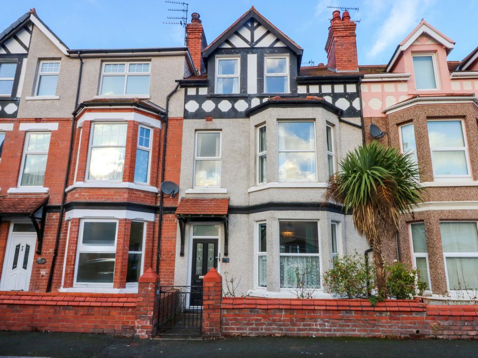 A house with multiple windows and a palm tree at Curzon Heights in Llandudno