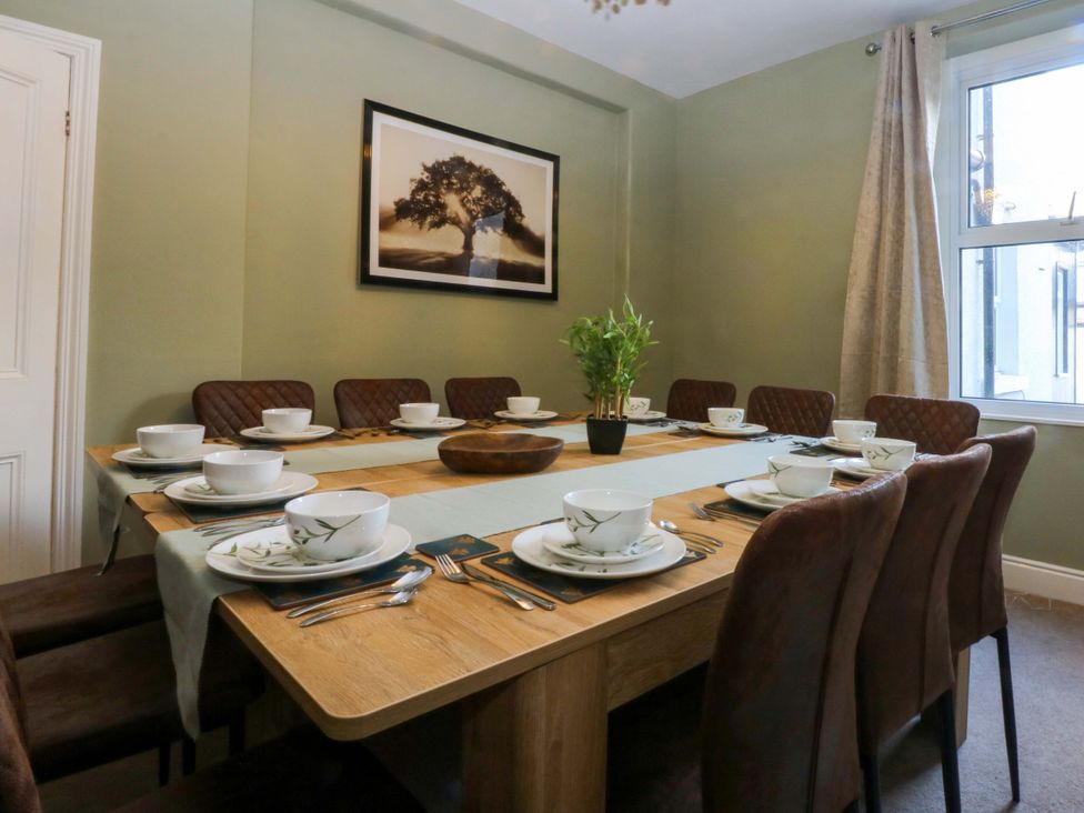 A dining room with a table set for meals at Curzon Heights in Llandudno