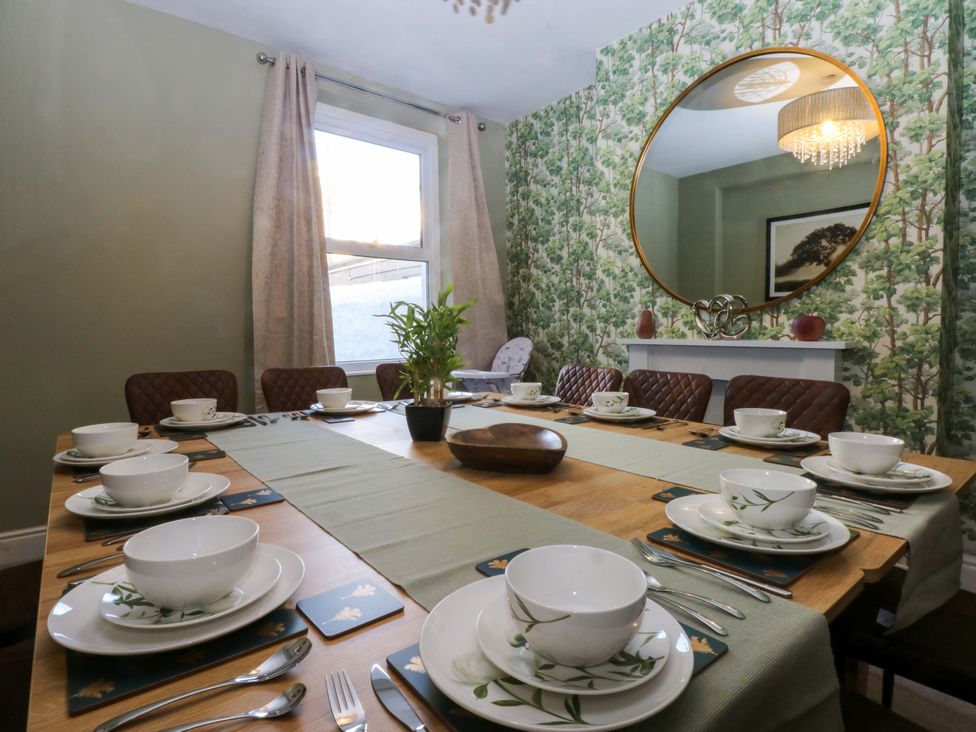 A dining room with a table set for meals at Curzon Heights in Llandudno