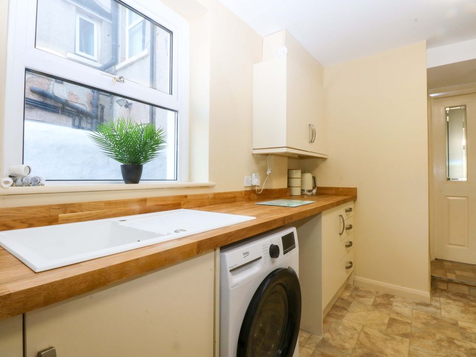 A kitchen with a sink and washing machine at Curzon Heights in Llandudno