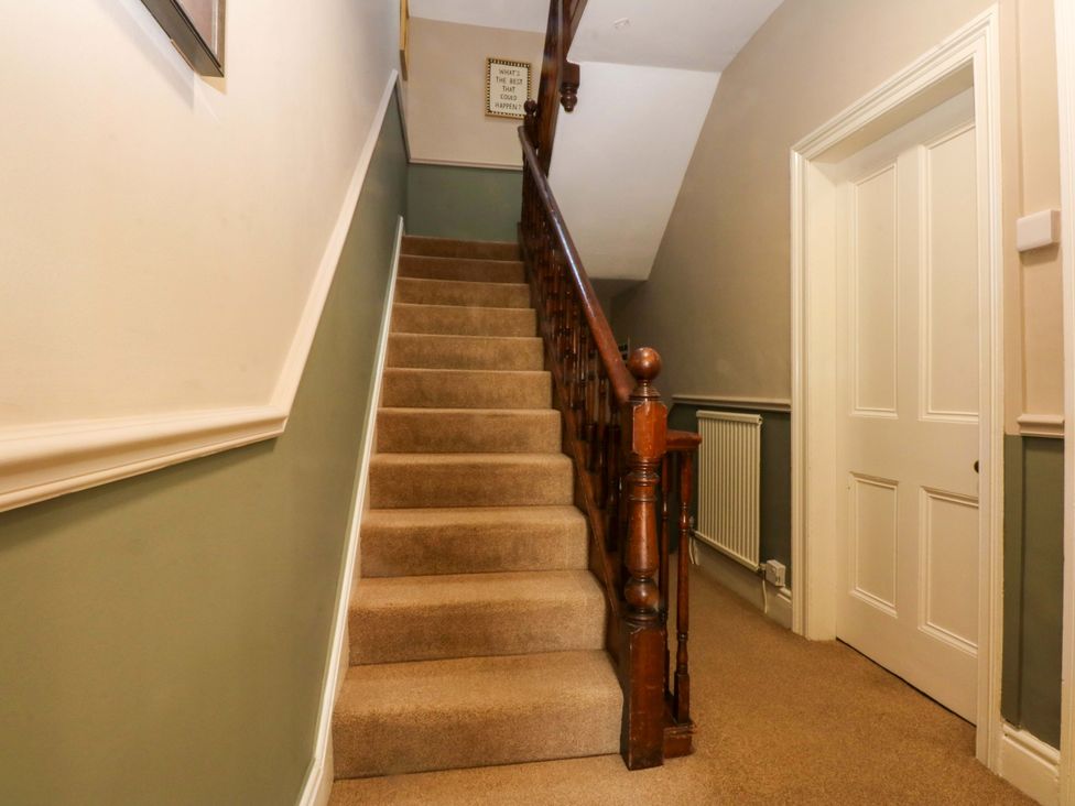 A staircase with a handrail in a hallway at Curzon Heights, Llandudno