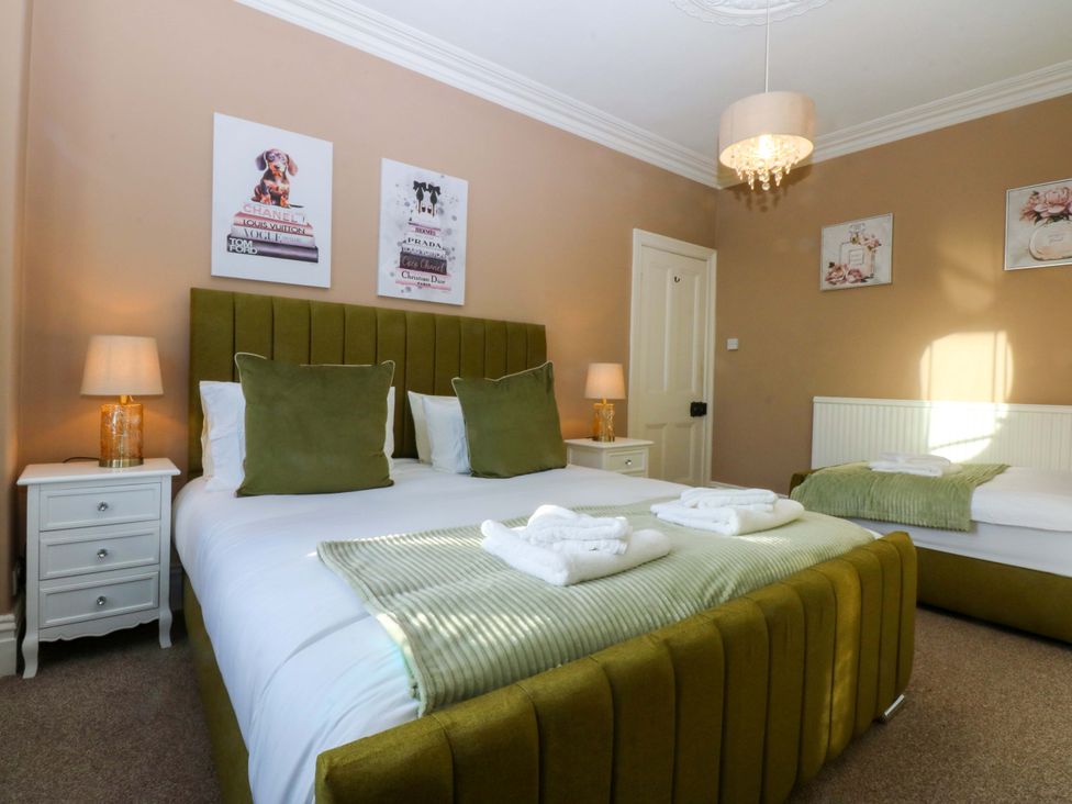 A bedroom with a large bed and bedside tables at Curzon Heights in Llandudno