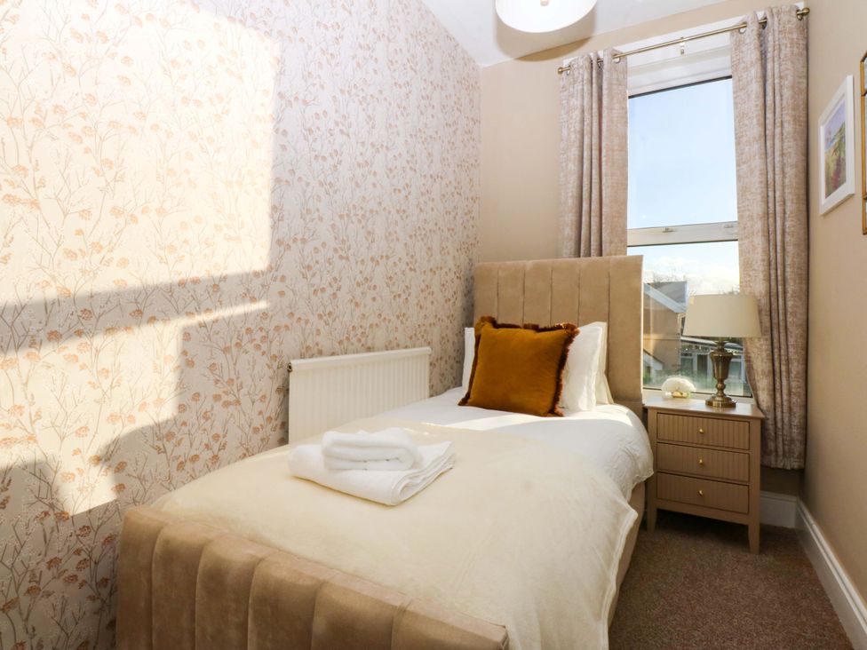 A bedroom with a single bed and nightstand at Curzon Heights in Llandudno