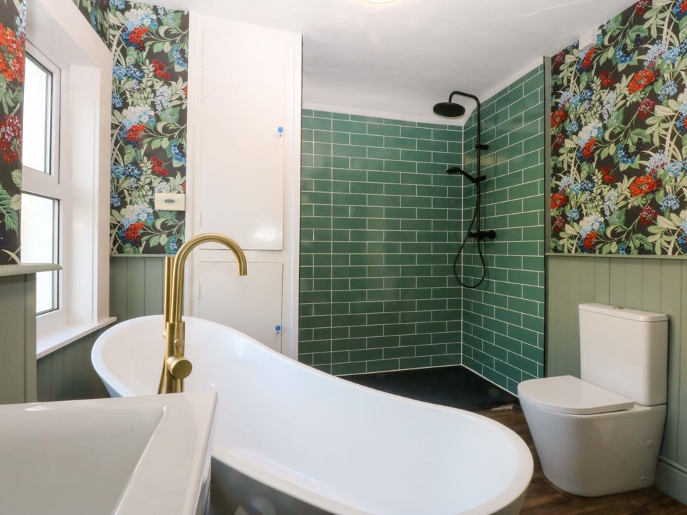 A bathroom with a bathtub and shower at Curzon Heights in Llandudno