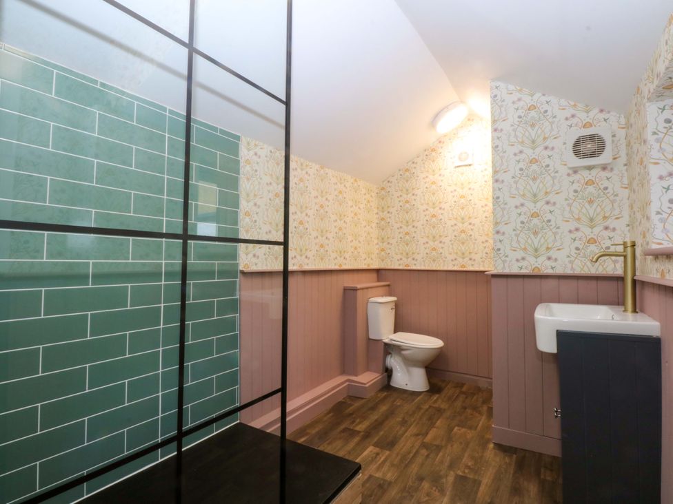 A bathroom with shower, toilet, and sink at Curzon Heights in Llandudno