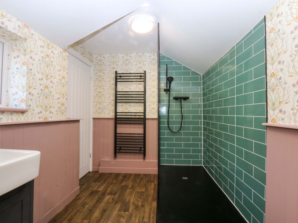 A bathroom with a shower and towel rail at Curzon Heights in Llandudno