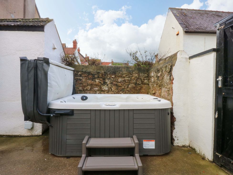 A hot tub with steps beside a wall at Curzon Heights in Llandudno