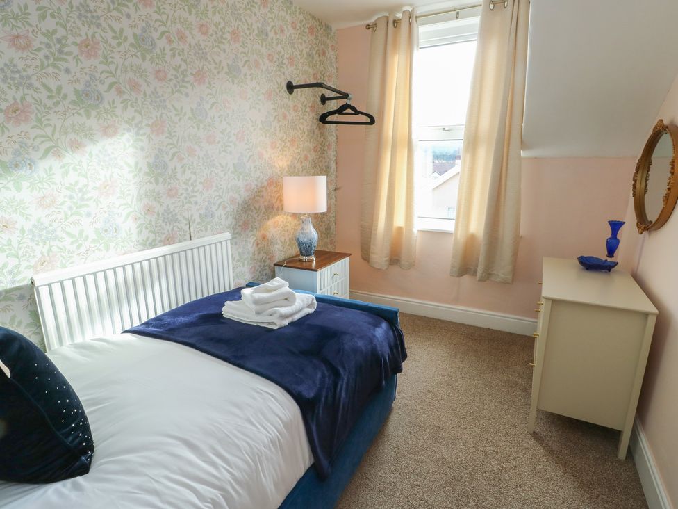 A bedroom with a bed and lamp at Curzon Heights in Llandudno