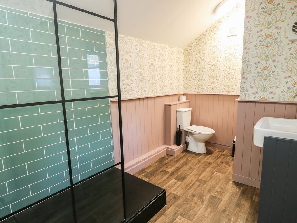 A bathroom with a shower, toilet, and sink at Curzon Heights in Llandudno