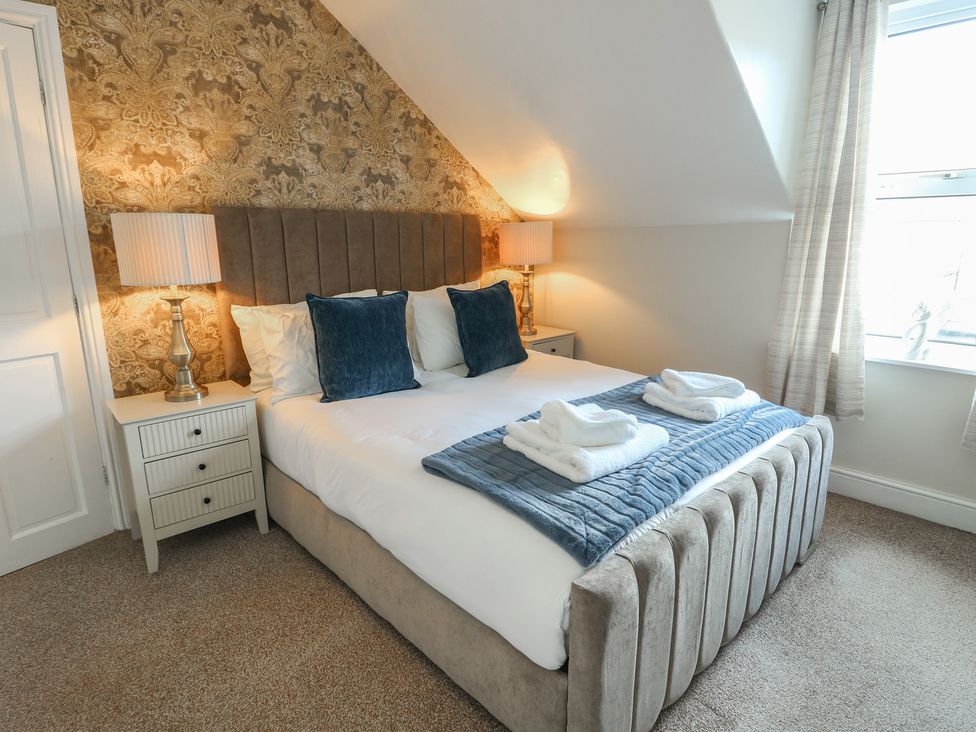 A bedroom with a bed and bedside tables at Curzon Heights in Llandudno