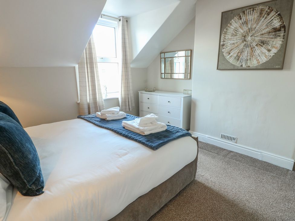 A bedroom with a bed and dresser at Curzon Heights in Llandudno
