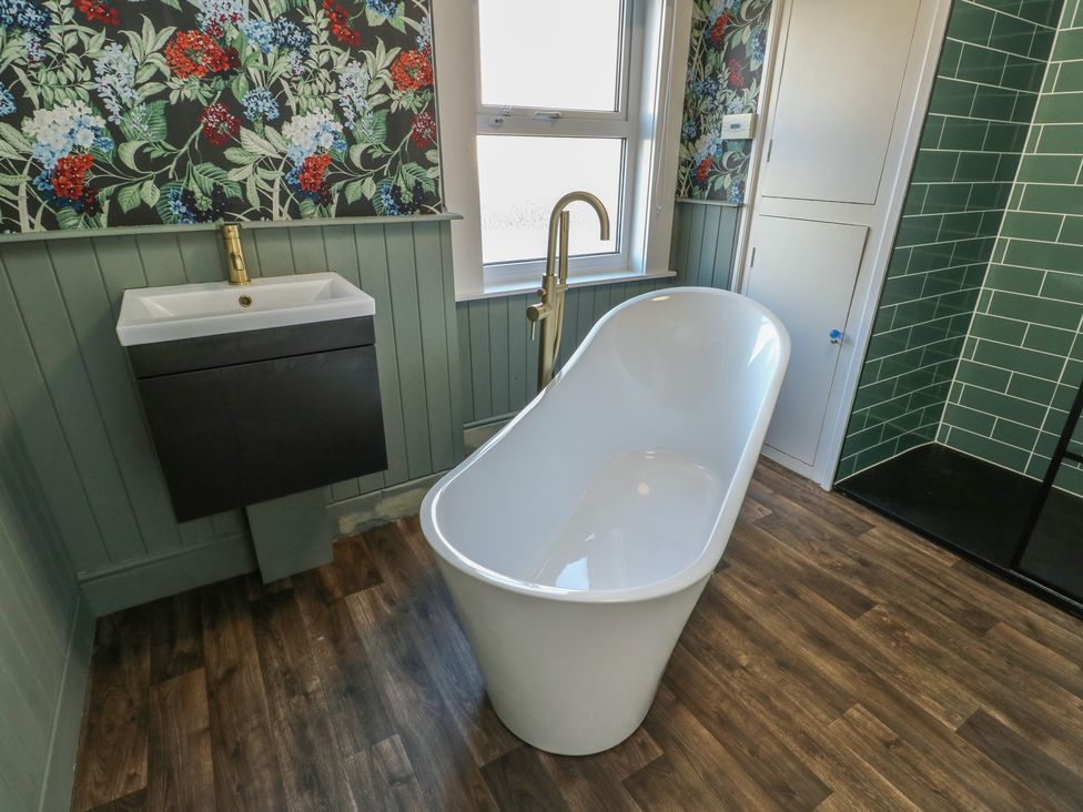 A bathroom with a bathtub and sink at Curzon Heights in Llandudno