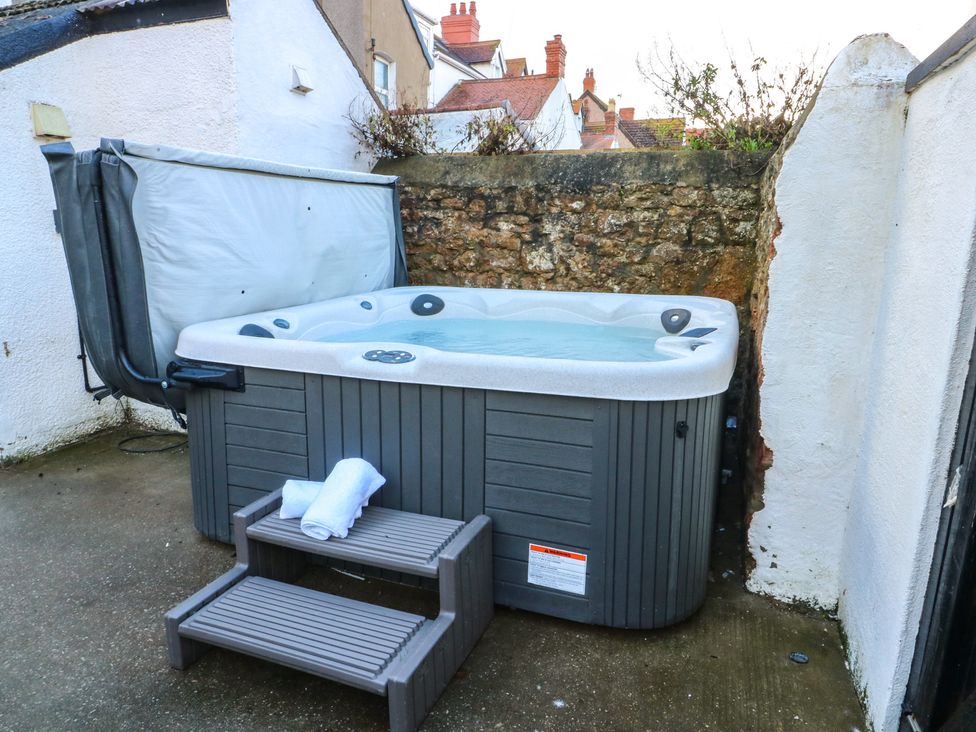 A hot tub with a towel on a stool in an outdoor space at Curzon Heights in Llandudno