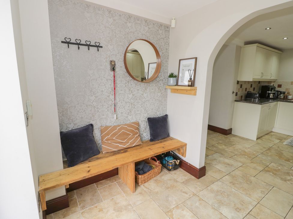 A hallway with a bench and wall hooks at Little Acre, Church Lench near Harvington