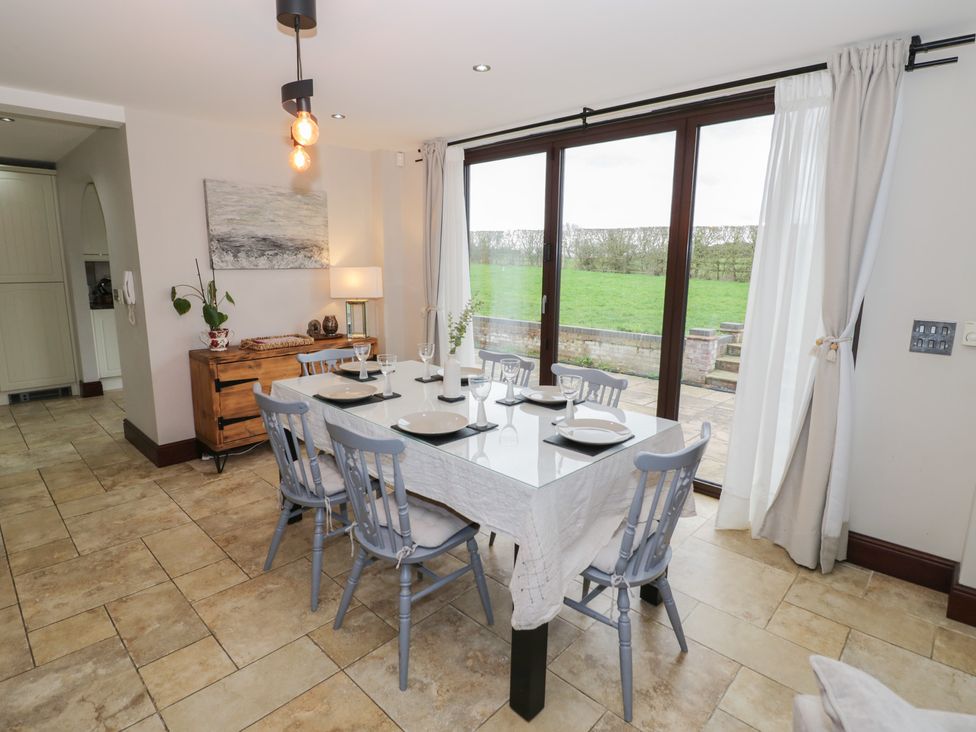 A dining room with a table set for dinner at Little Acre in Church Lench near Harvington