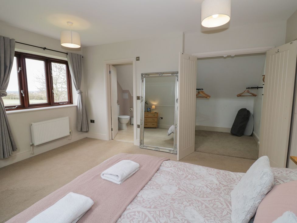 A bedroom with a bed and window at Little Acre Church Lench near Harvington