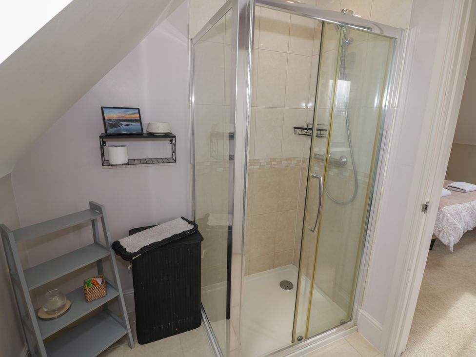 A bathroom with a shower and shelf at Little Acre in Church Lench near Harvington
