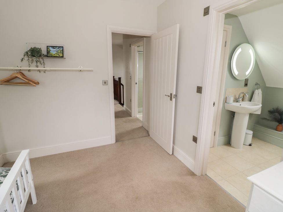 A bedroom with a bed and bathroom access at Little Acre, Church Lench near Harvington