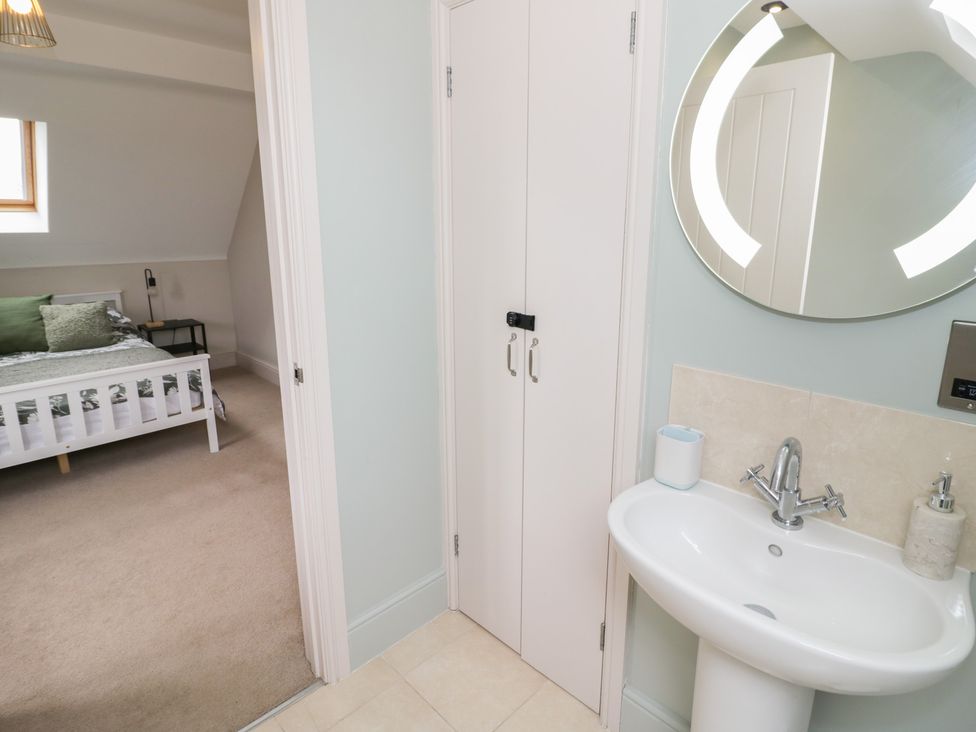 A bedroom area with a sink and cupboard at Little Acre in Church Lench near Harvington