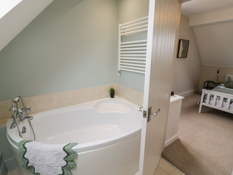 A bathroom with a bathtub and towel rack at Little Acre Church Lench near Harvington