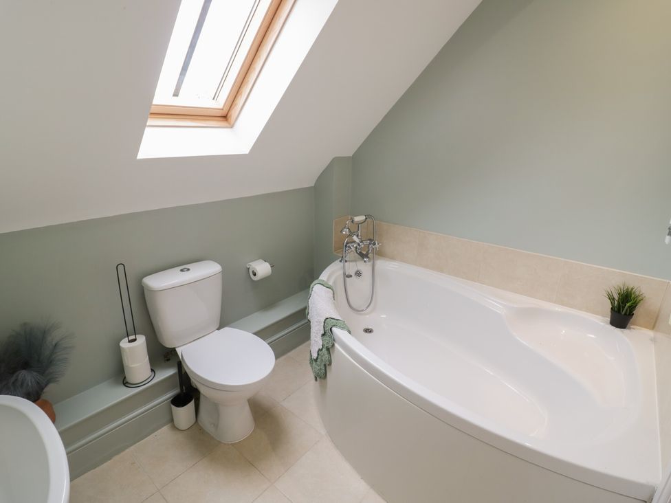 A bathroom with a bathtub and toilet at Little Acre in Church Lench near Harvington