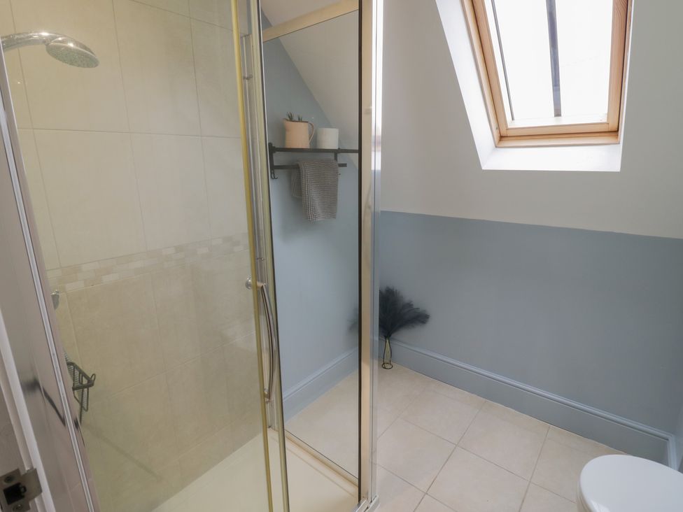 A bathroom with a shower, toilet, and sink at Little Acre in Church Lench near Harvington