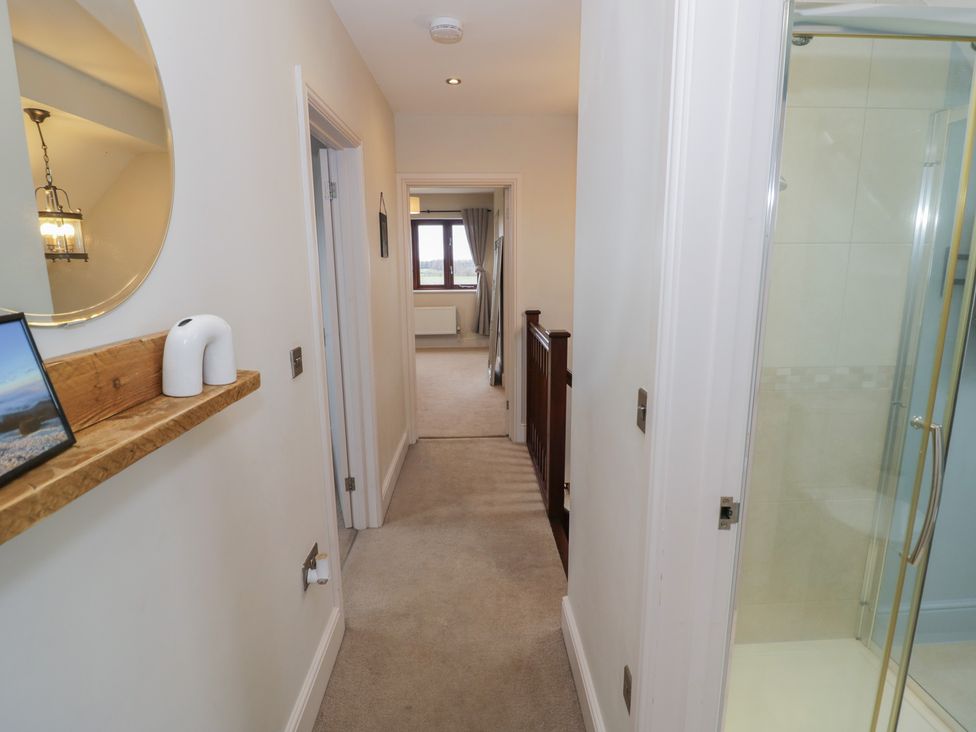 A hallway with a mirror and shelf at Little Acre Church Lench near Harvington