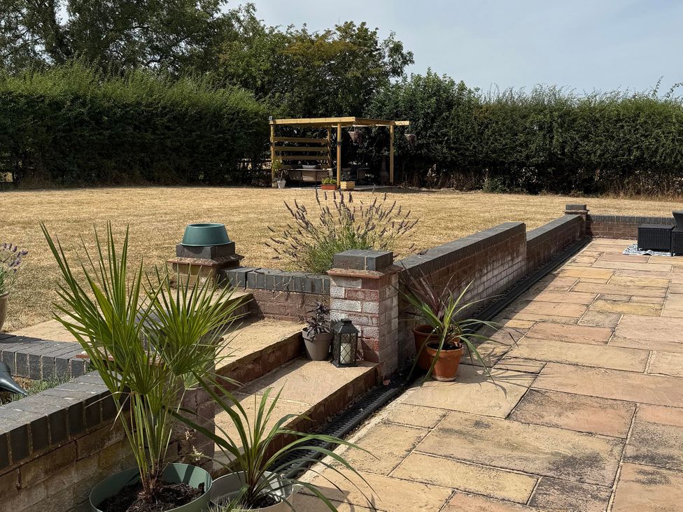 A garden with paving stones and plants at Little Acre Church Lench near Harvington