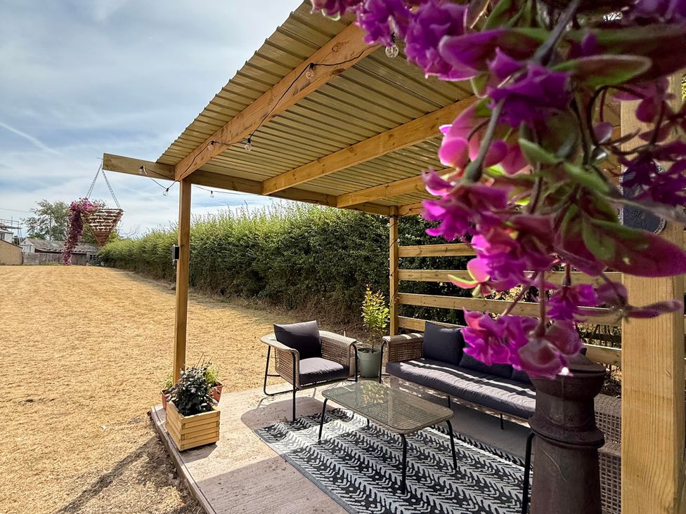 An outdoor seating area with a sofa and table at Little Acre in Church Lench near Harvington