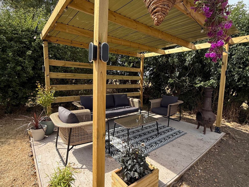 An outdoor seating area with a sofa and coffee table at Little Acre Church Lench near Harvington