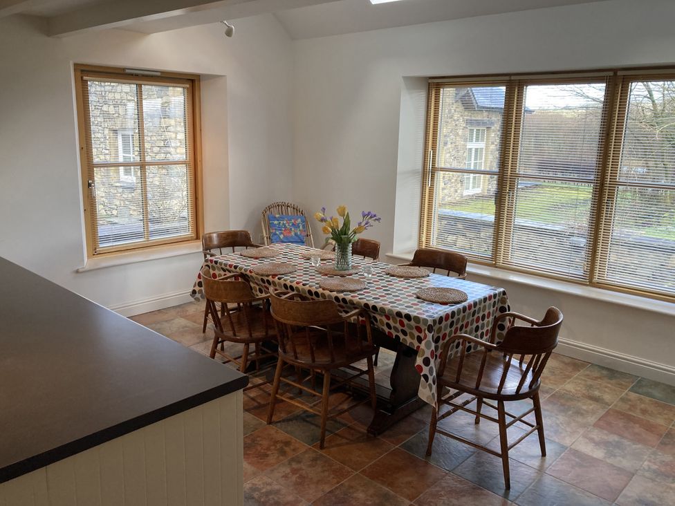 A dining room with a table and chairs at Bryn Isaf in Ystrad Meurig