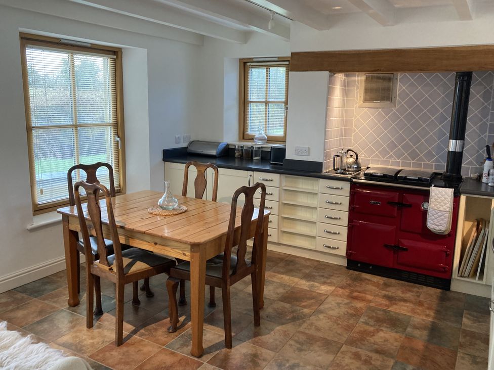 A kitchen with a table and chairs at Bryn Isaf in Ystrad Meurig