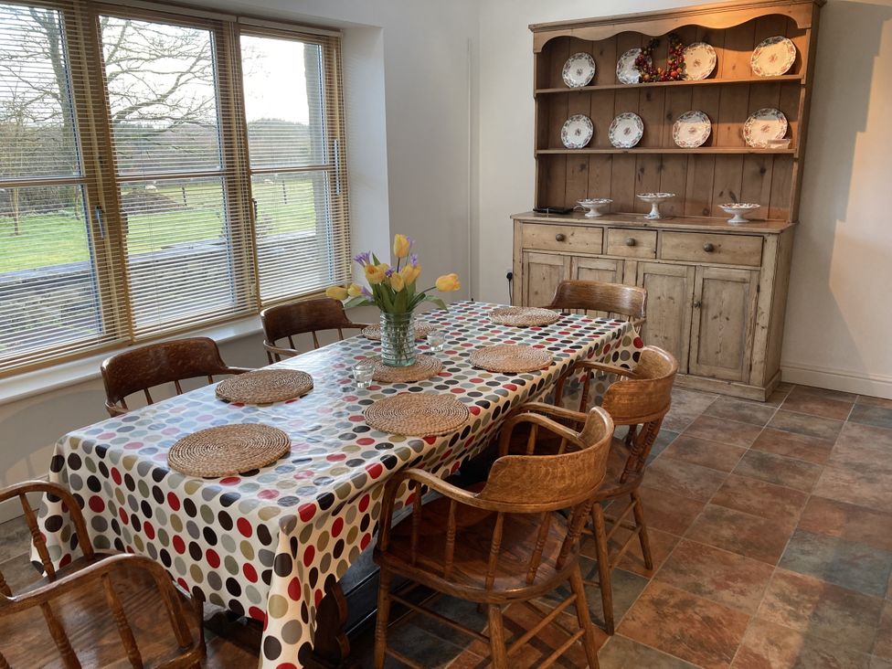 A dining room with a table and chairs at Bryn Isaf in Ystrad Meurig
