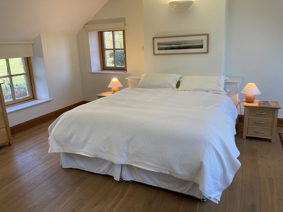 A bedroom with a bed and two lamps at Bryn Isaf in Ystrad Meurig