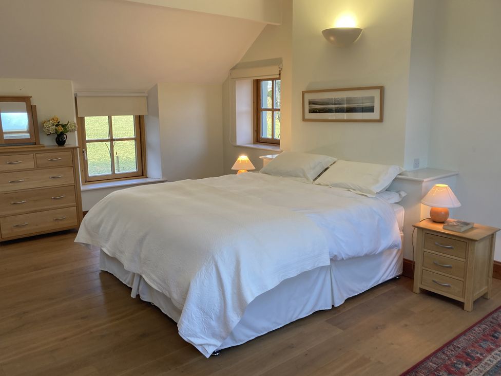 A bedroom with a bed and a dresser at Bryn Isaf in Ystrad Meurig
