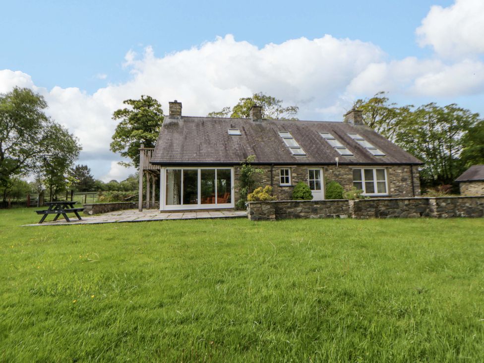 A house with a stone exterior and grass in front at Bryn Isaf in Swyddffynnon near Pontrhydfendigaid