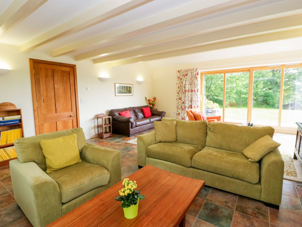 A living room with sofas, a table, and a window at Bryn Isaf near Swyddffynnon near Pontrhydfendigaid