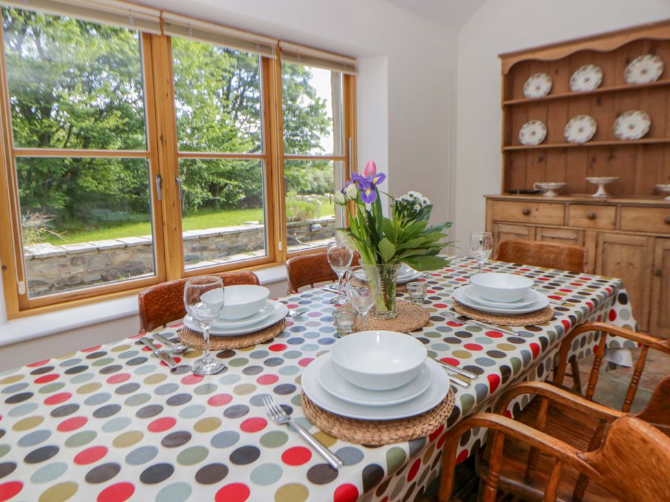 A dining room with a table set and a flower vase at Bryn Isaf in Swyddffynnon near Pontrhydfendigaid