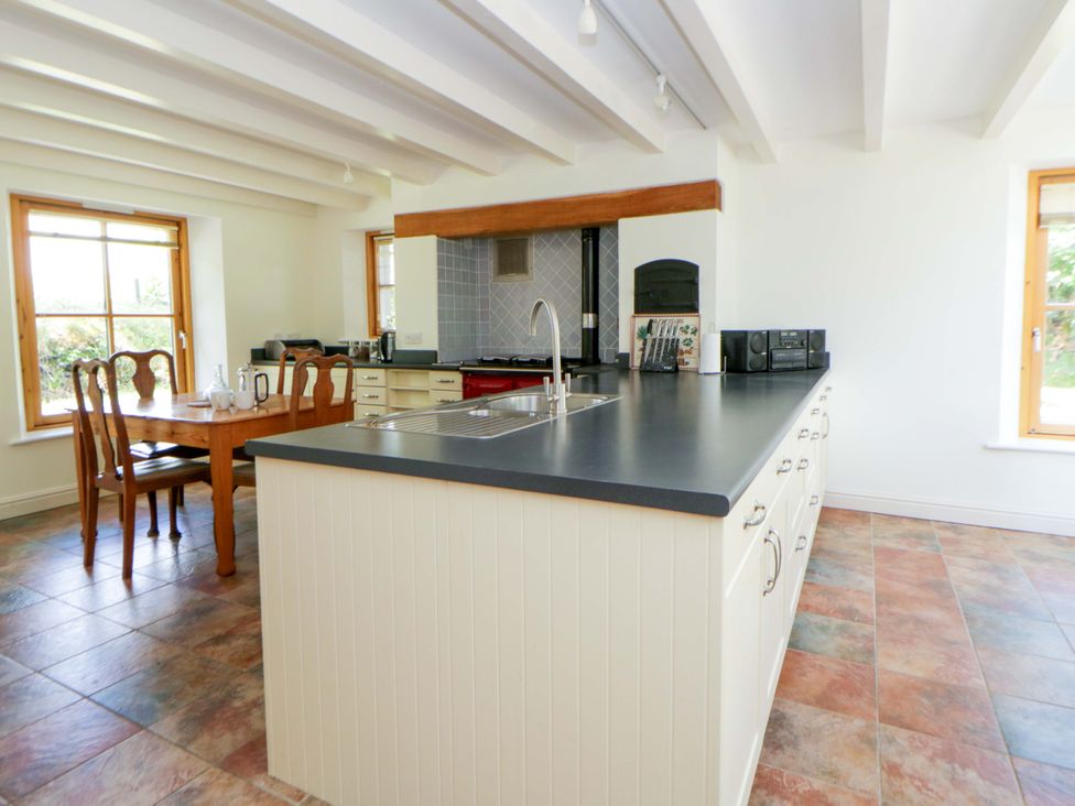 A kitchen with a dining table and countertop at Bryn Isaf in Swyddffynnon near Pontrhydfendigaid