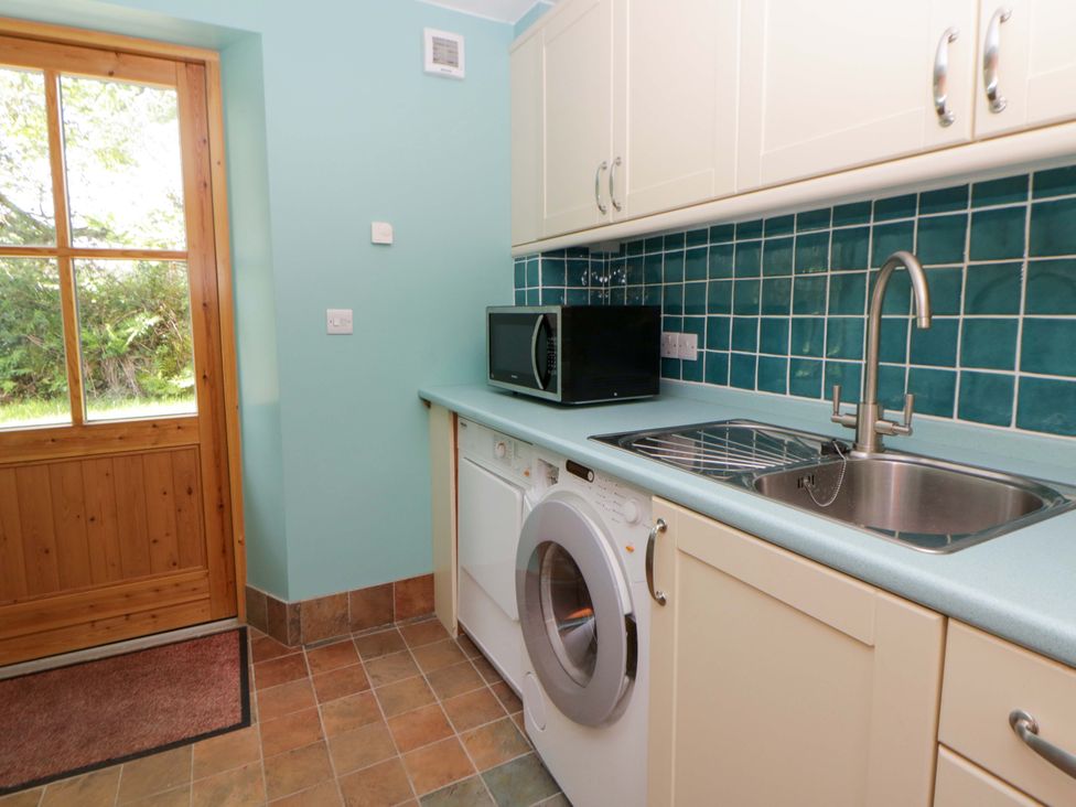 A utility room with a washing machine and microwave at Bryn Isaf in Swyddffynnon near Pontrhydfendigaid