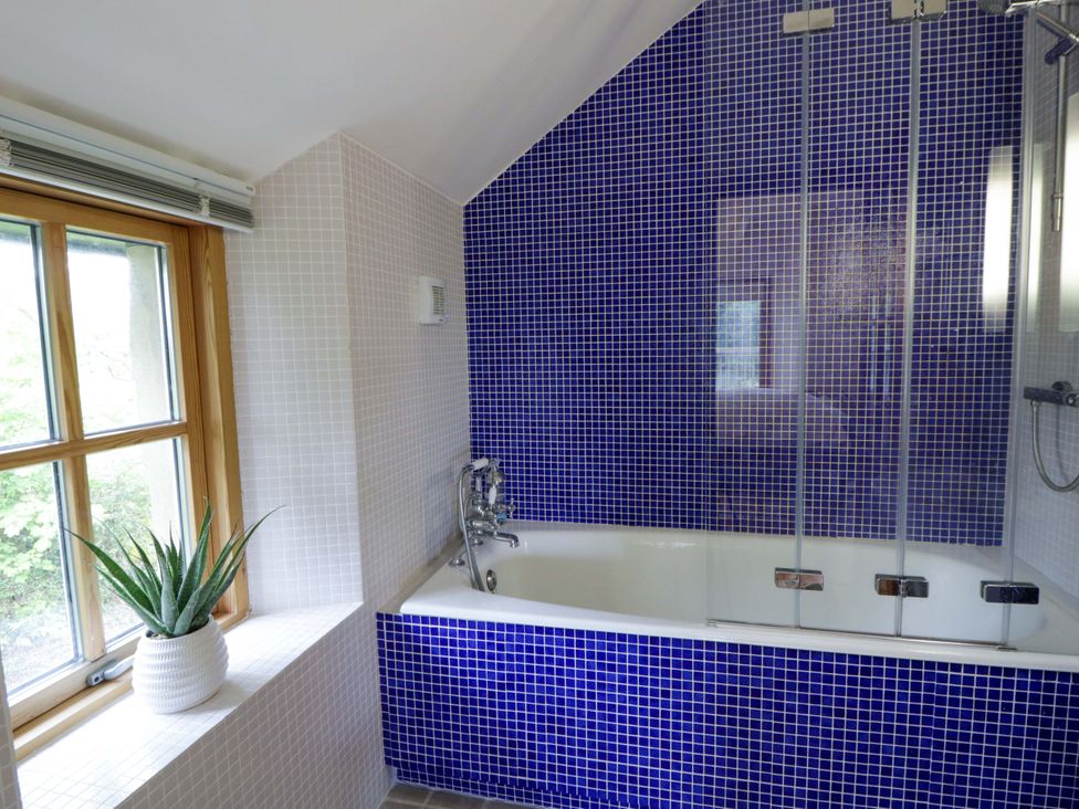 A bathroom with a bathtub and a window at Bryn Isaf in Swyddffynnon near Pontrhydfendigaid