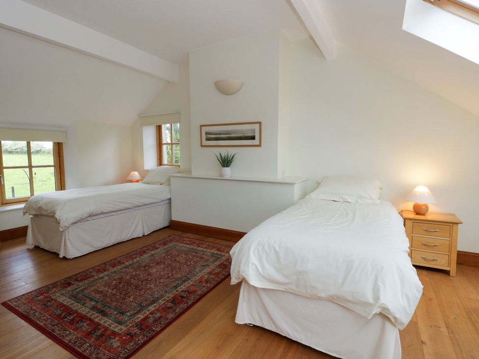A bedroom with two beds and a window at Bryn Isaf, Swyddffynnon near Pontrhydfendigaid