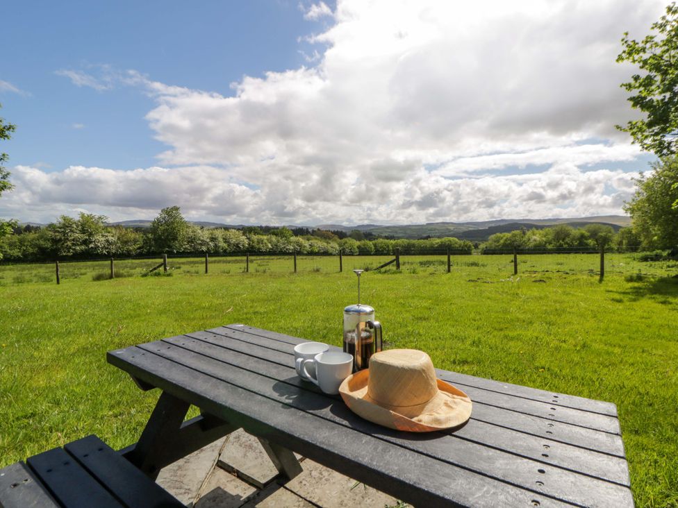 A table with a coffee pot and cups in a garden at Bryn Isaf in Swyddffynnon near Pontrhydfendigaid
