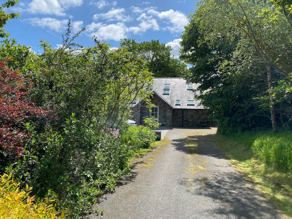 A house with a pathway surrounded by trees and bushes at Ty Cellin Ystrad Meurig