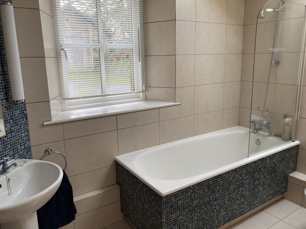 A bathroom with a bathtub and sink at Ty Cellin in Ystrad Meurig