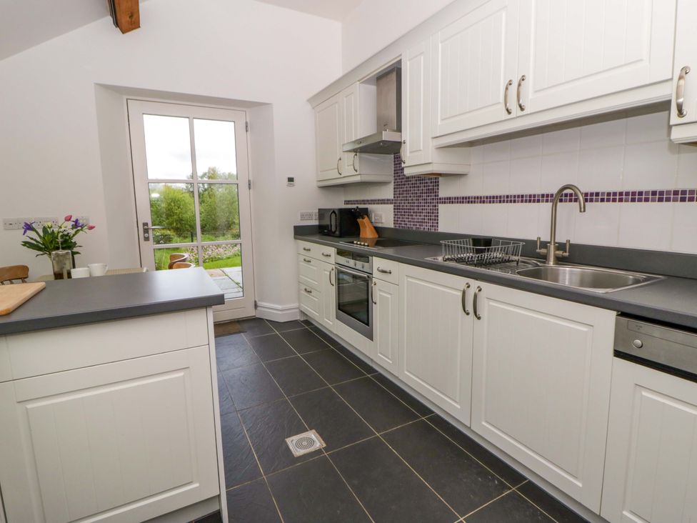 A kitchen with appliances and a door to the outdoors at Ty Cellin in Swyddffynnon near Pontrhydfendigaid