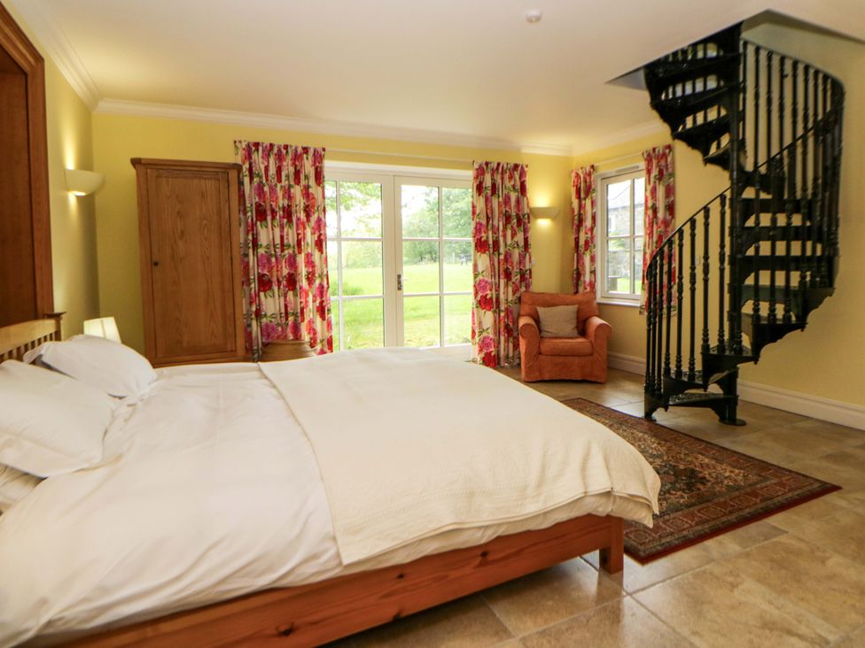 A bedroom with a bed and a spiral staircase at Ty Cellin in Swyddffynnon near Pontrhydfendigaid