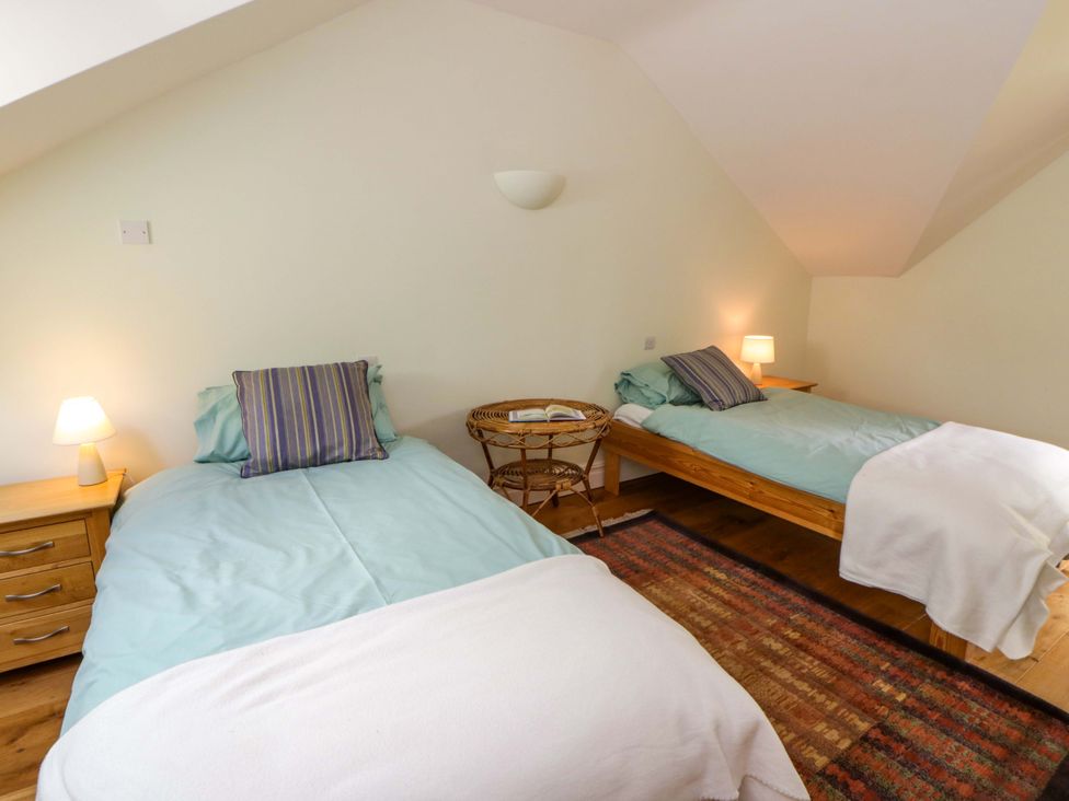 A bedroom with two beds and a lamp at Ty Cellin near Pontrhydfendigaid